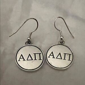 Silver Alpha Delta Pi sorority earrings.